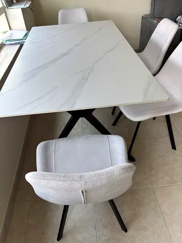White marble-effect dining table with 4 grey upholstered chairs