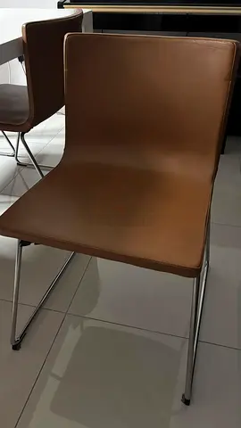 Set of 4 brown faux-leather dining chairs with metal legs with the dining table