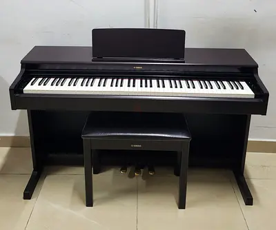The Yamaha YDP-165R is a premium, full-sized 88-key digital console piano in a matte dark rosewood