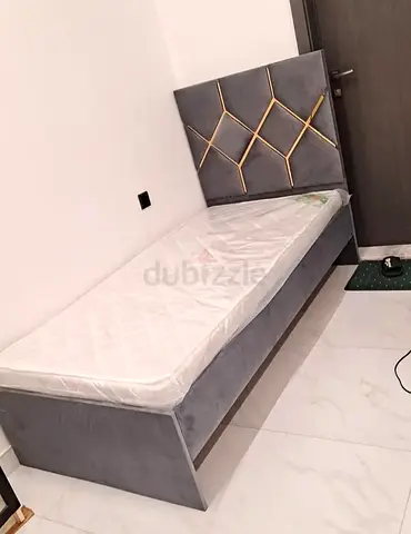 Single grey upholstered bed with decorative headboard and mattress - good condition