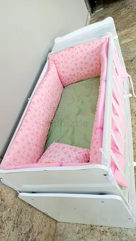 White wooden baby crib with pink bedding - gently used