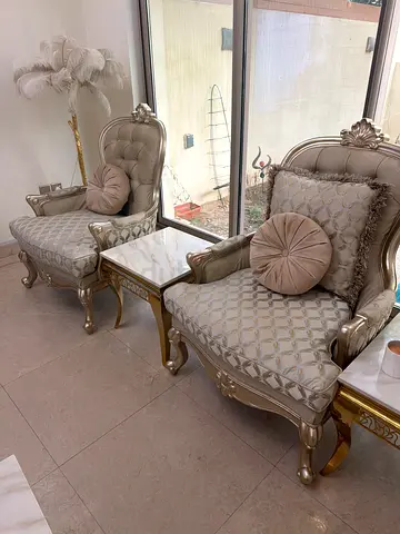 Pair of elegant carved wooden lounge chairs with tufted upholstery - light beige