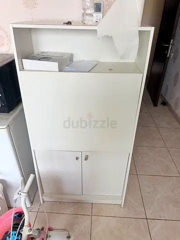 White wooden storage cabinet with drop-front and lower double doors