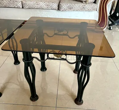 Glass top metal coffee table with decorative base
