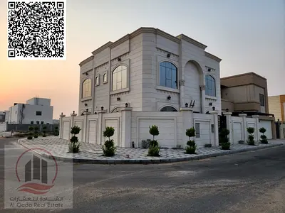 Corner villa for sale in Al Alia, Ajman, area 3500 square feet. The villa (5 rooms + majlis + hall + large courtyard + equipped kitchen + maid’s room)