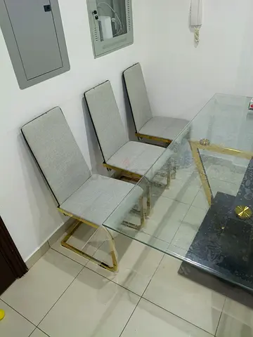 Set of 6 modern grey upholstered dining chairs and table with gold metal frame.