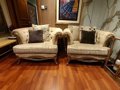 Pair of classic beige upholstered arm sofa chairs with carved wooden frames excellent shape