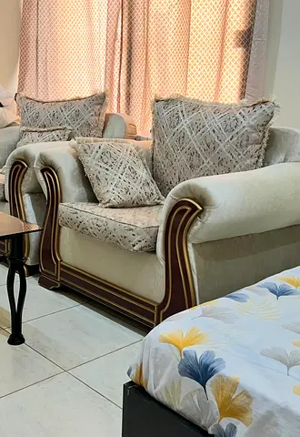 Beige upholstered two single seater sofa set with decorative cushions