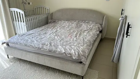 Light grey upholstered king bed frame with curved headboard