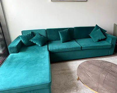 L-shaped green velvet sofa