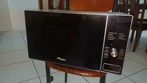 Used Black Microwave Oven - Partially Working Condition. Needs repair.