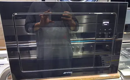 Premium SMEG built-in microwave with elegant black glass finish..