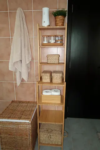 Tall slim wooden bathroom shelf with wicker baskets