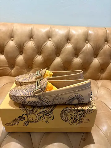 Tod’s ladies’ Gommino leather driving loafers featuring a dragon-inspired print, beige leather. 38