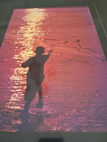 Framed Photograph of Child Casting a Line at Sunset, 63 x 51 cm
