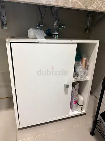 Small white under-sink bathroom cabinet with single door