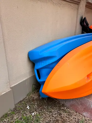 Two sit-on-top kayaks – orange and blue, brand new occasionally used with oars