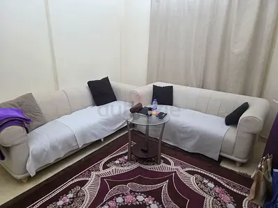 L-shaped cream fabric sofa set with floral rug