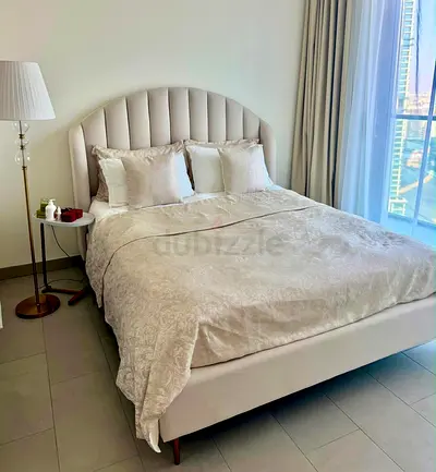 Upholstered queen bed with curved headboard - light beige. Mattress included