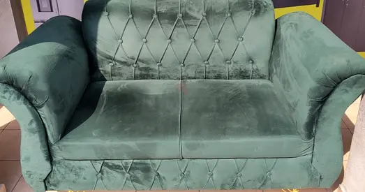 Green velvet 2-seater sofa — good condition