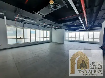 Semi-partitioned office, free AC, 2 free parking spaces, 2 bathrooms, shared kitchen, large area, Al Majaz Park view, prime location in Al Majaz 2 nea