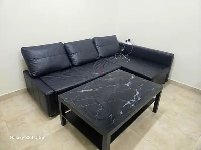 Black L-shaped Leather Sofa with Marble Effect Coffee Table - Good Condition