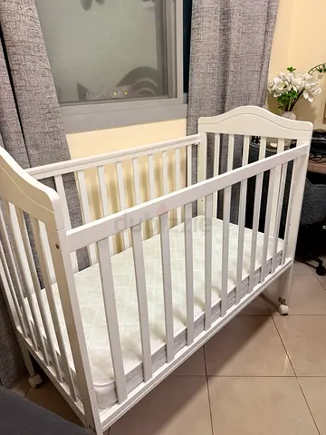 White wooden baby crib in Excellent condition, includes mattress and baby comfort sets