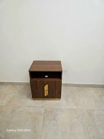 Compact wooden bedside table with storage and brass accents