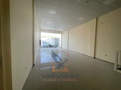 معرض تجاري على شارع رئيسي في الجرف الصناعية 2 مع ميزانين ونظام فاير سيستم حديث ومساحة عملية تناسب مختلف الأنشطة