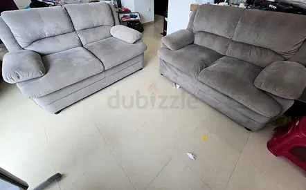 Pair of comfortable grey 2-seater sofas in good used condition