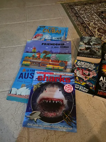 Collection of children's and non-fiction books including 'Sharks' and 'Friends Hub Dubai'