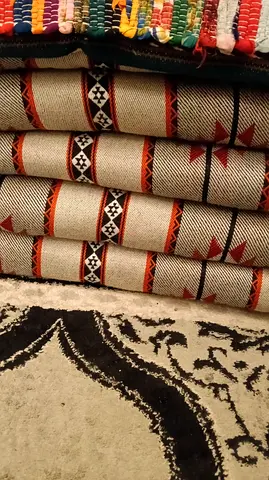 Stack of Geometric Tribal Floor Rugs — Good Used Condition