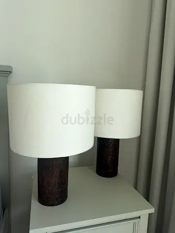 Pair of wooden base table lamps with beige drum shades both 90Dhs