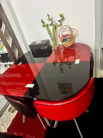 Compact glass-top dining table with 4 red & black chairs