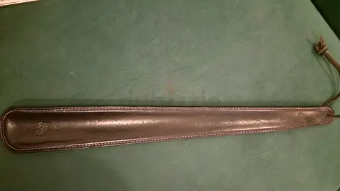 ​Long, premium leather-wrapped shoe horn featuring a classic stork embossing.