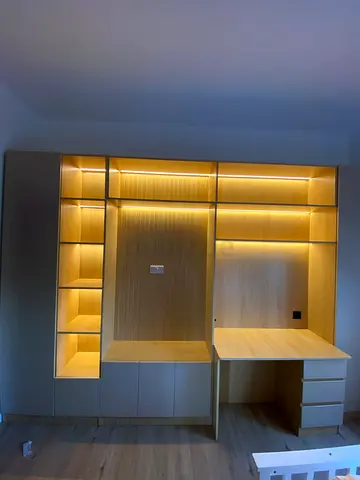 Custom built-in wooden wardrobe with integrated desk and LED lighting