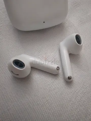 Used white wireless earbuds with charging case (looks like Apple AirPods style)