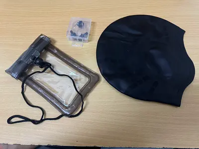 Swim cap with waterproof phone pouch and earplugs