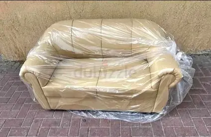 Two-seater beige leather sofa in good condition