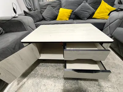 Modern light-wood coffee table with storage drawers and cabinet
