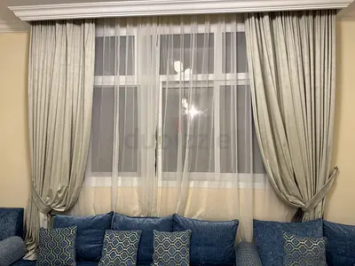 Elegant custom-made grey blackout curtains with white sheer curtains and matching tiebacks.