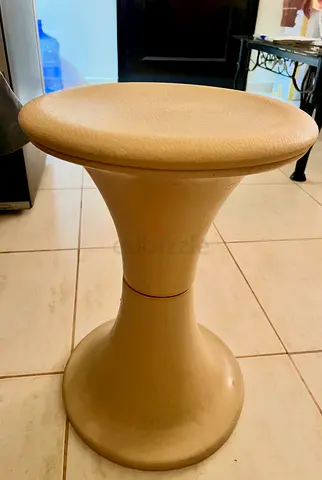 Beige plastic round stool with detacheble padded seat — compact and lightweight