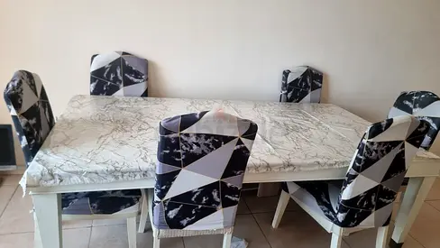 White wooden dining table with 6 geometric-patterned chairs