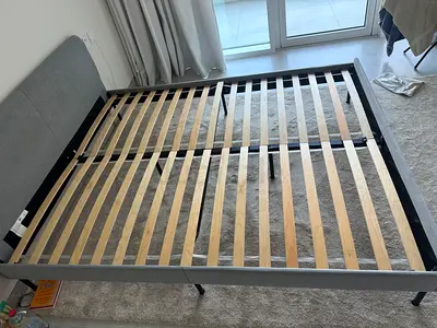 Queen size bed frame with wooden slats and grey upholstered headboard