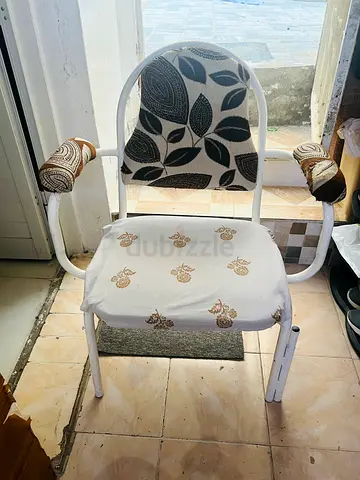 Used white metal armchair with padded back and armrests