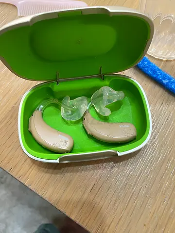 Pair of used behind-the-ear hearing aids with charging/storage case